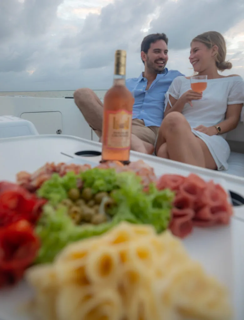 A couple relaxing together beside an outdoor dining table on a yacht